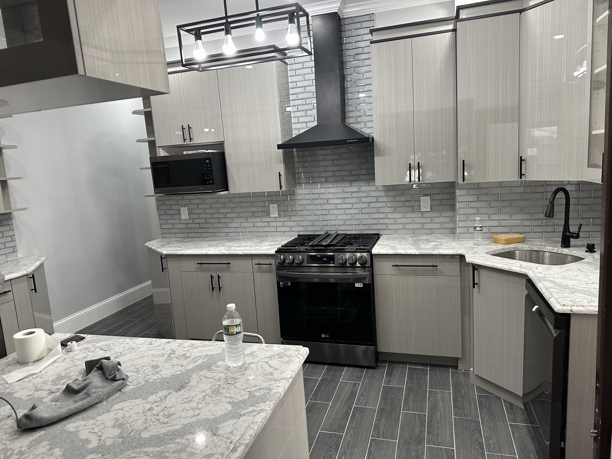 Silver Reed sample 067 installed in a completed kitchen with black hardware and a grey tile backsplash