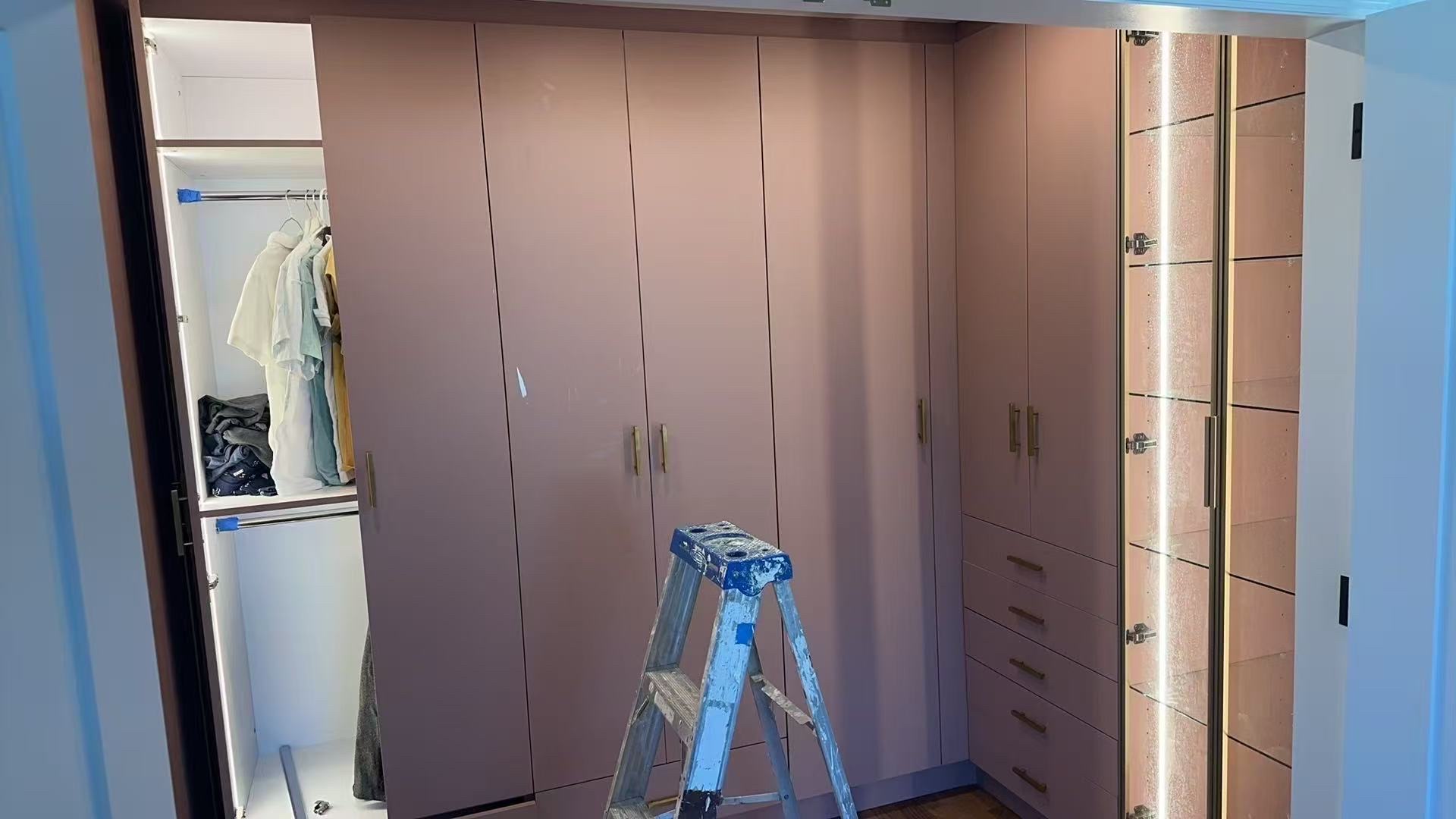 Custom closet installation in progress using sample 5005 cabinetry with gold hardware