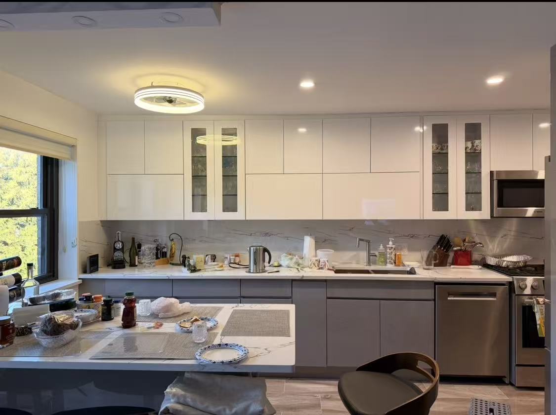 Sample 8805 glossy white upper cabinets in a two-tone kitchen with gray base cabinets and glass display doors