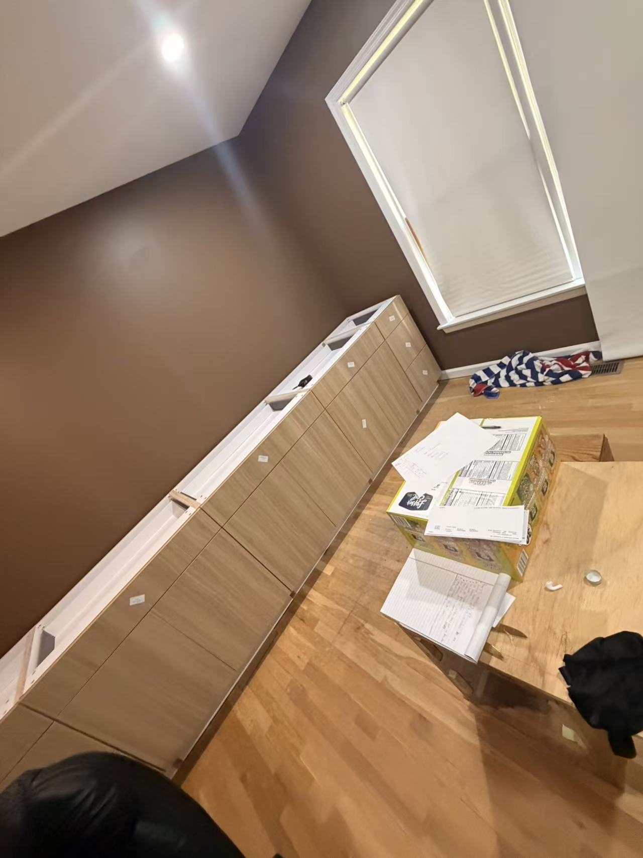 Sample T300 light wood-grain base cabinets installed along a dining room wall during construction