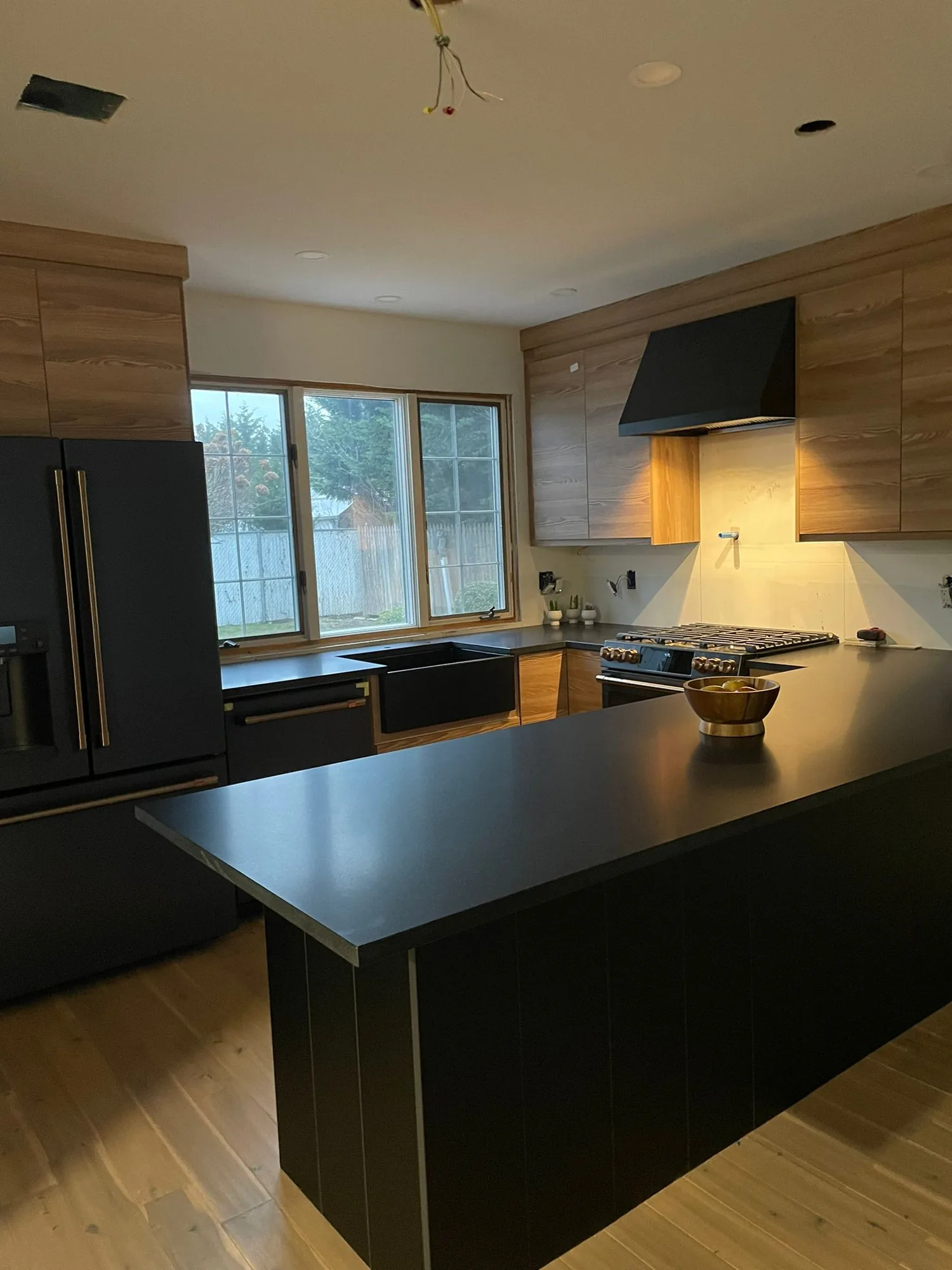 Black and natural wood kitchen with a large dark island